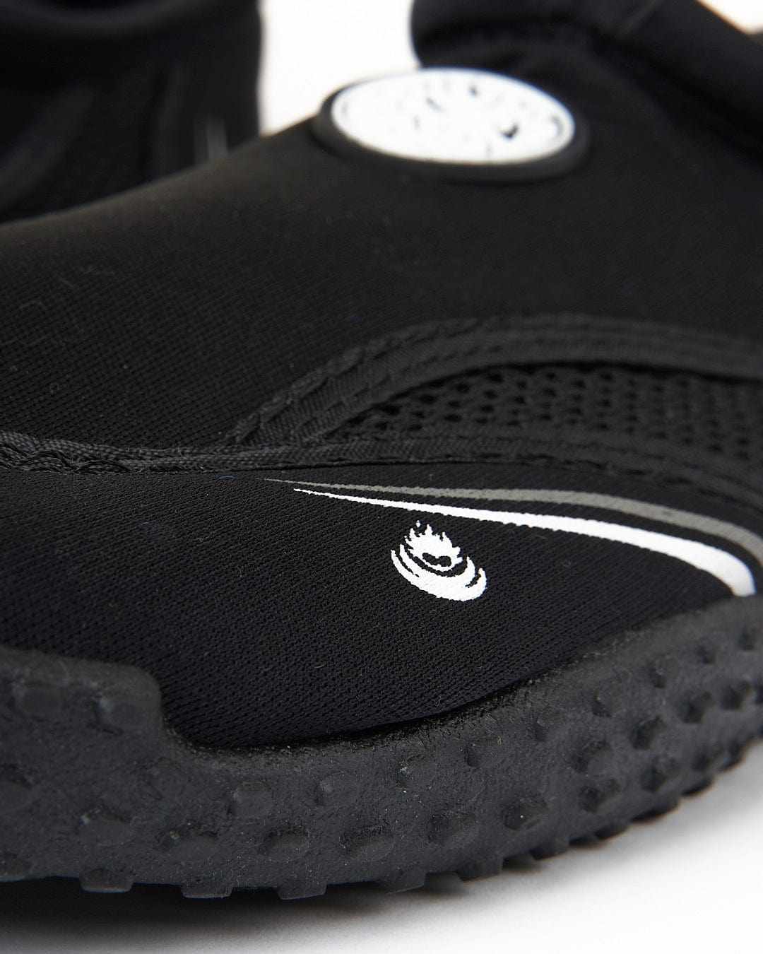 Close-up of a Saltrock Core Aqua Shoe - Black featuring a white logo on the side and a circular dial.