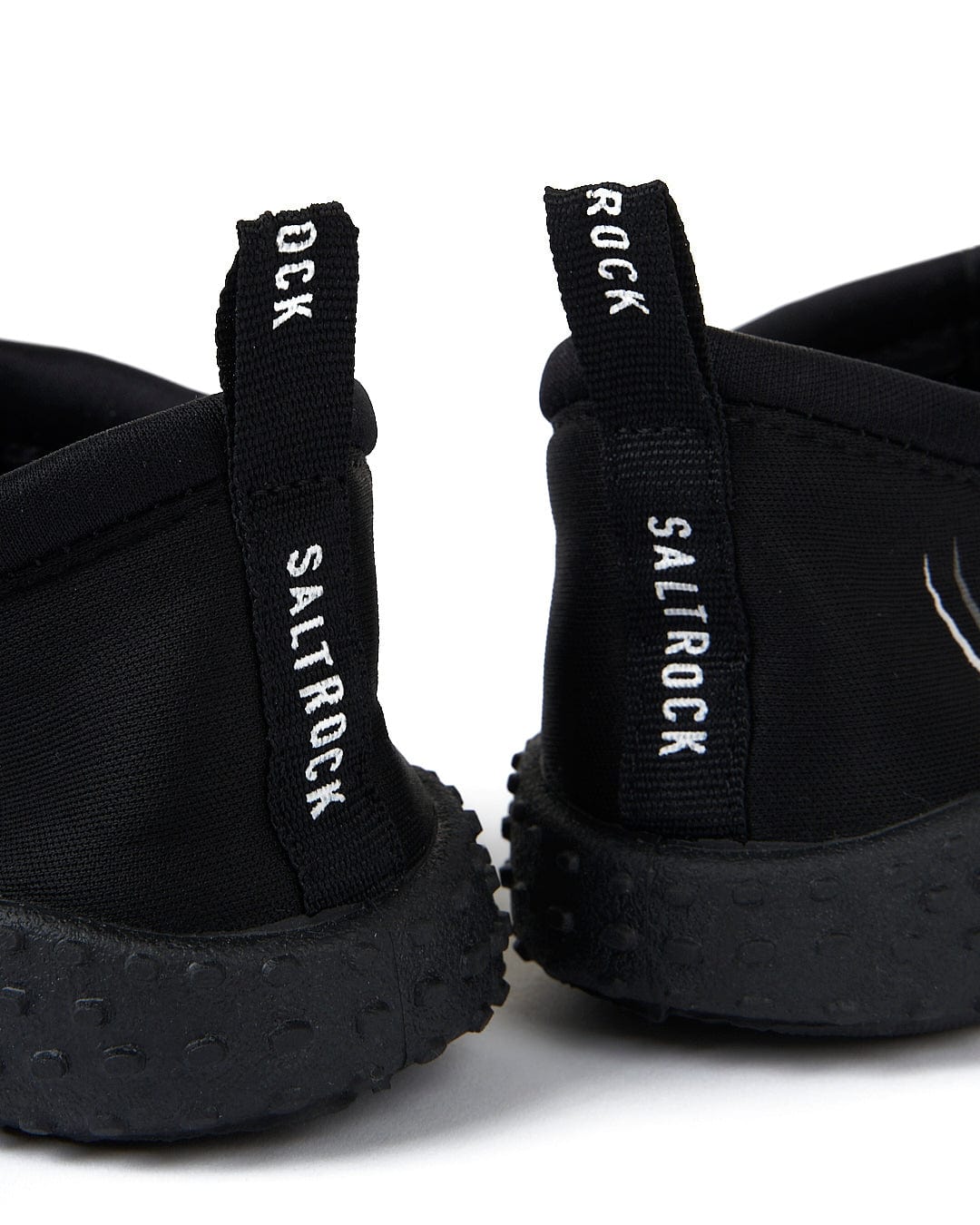 Core Aqua Shoe - Black slip-on shoes with Saltrock text on the heel tabs, white logo on the side, against a white background.