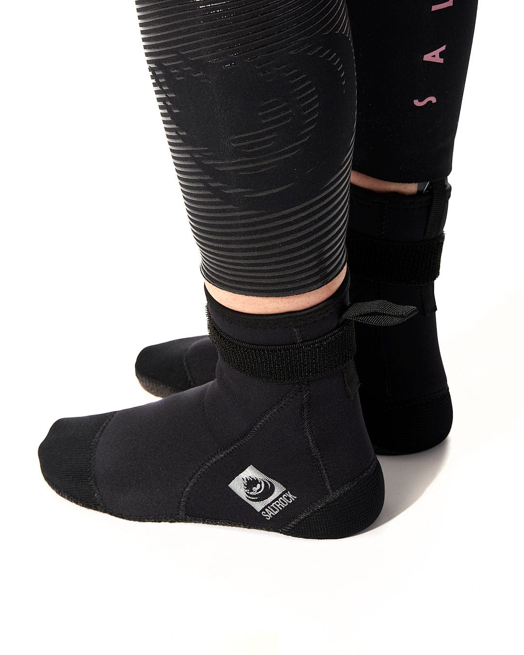 A woman wearing a pair of Saltrock Core - Wetsuit Boot - Black neoprene socks.