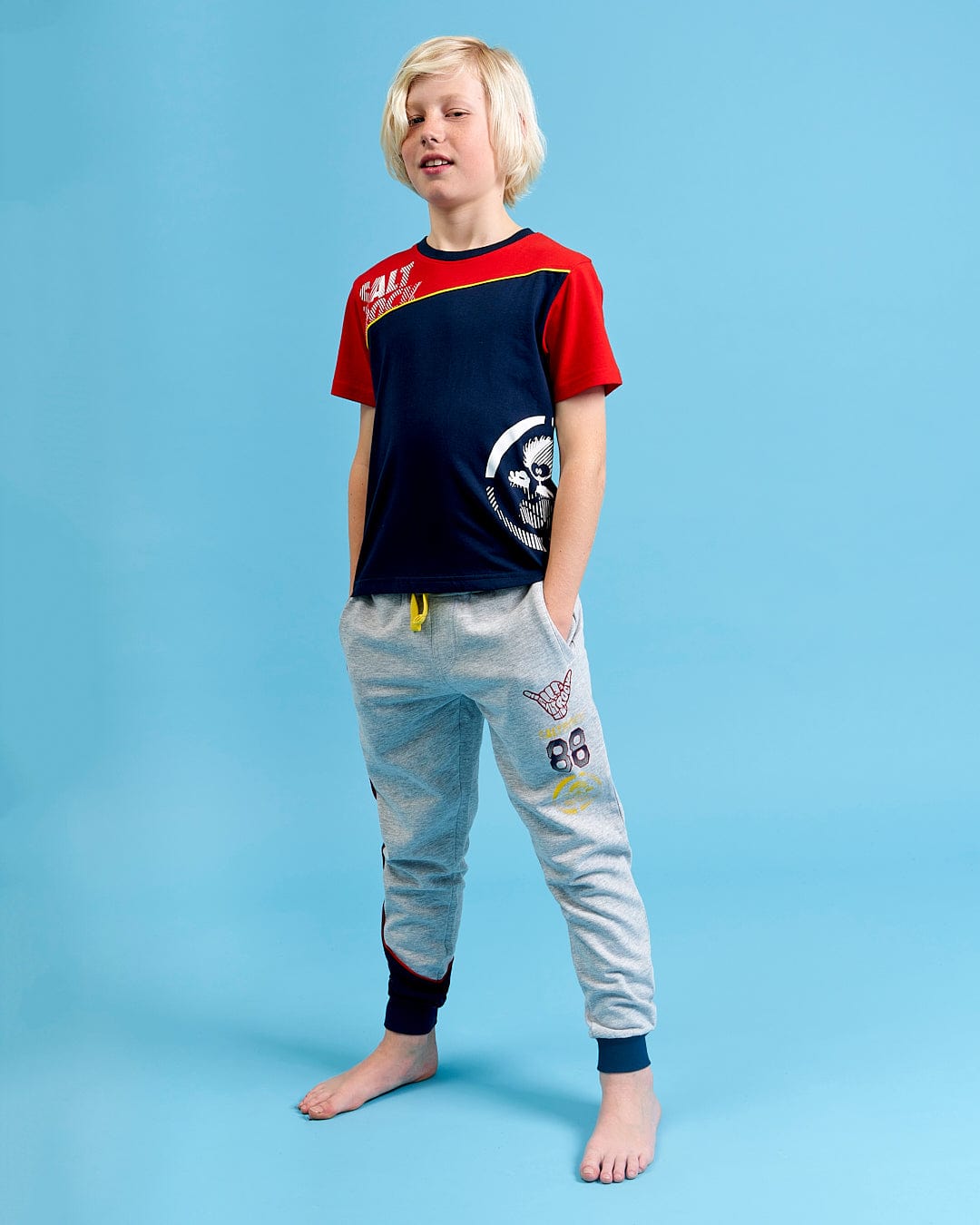 A young boy wearing a Saltrock Curby - Kids Jogger - Grey t-shirt and jogging pants.