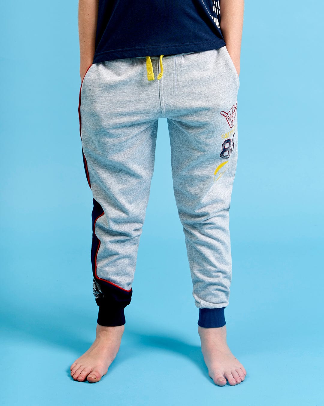 A young boy wearing a pair of Saltrock Curby - Kids Jogger - Grey jogging pants.