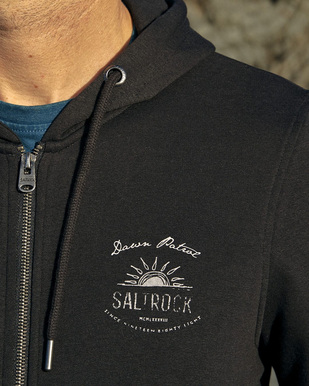 A man wearing a Dawn Patrol - Mens Zip Hoodie - Black with the brand name Saltrock on it.