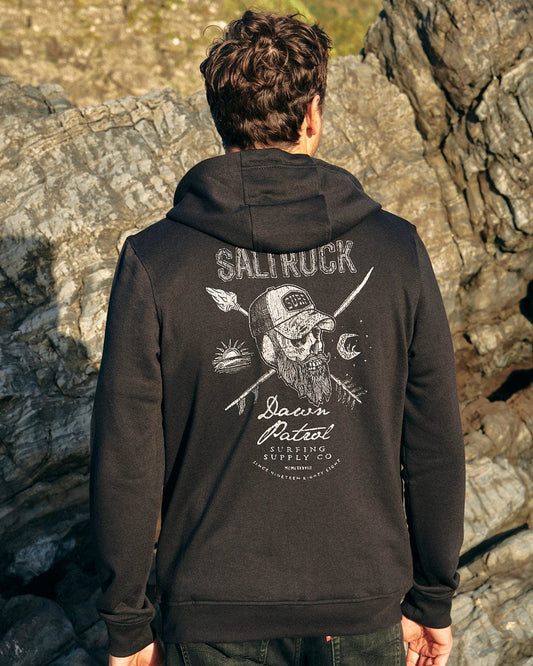 The back of a man wearing a Saltrock Dawn Patrol - Mens Zip Hoodie - Black with a skull on it.