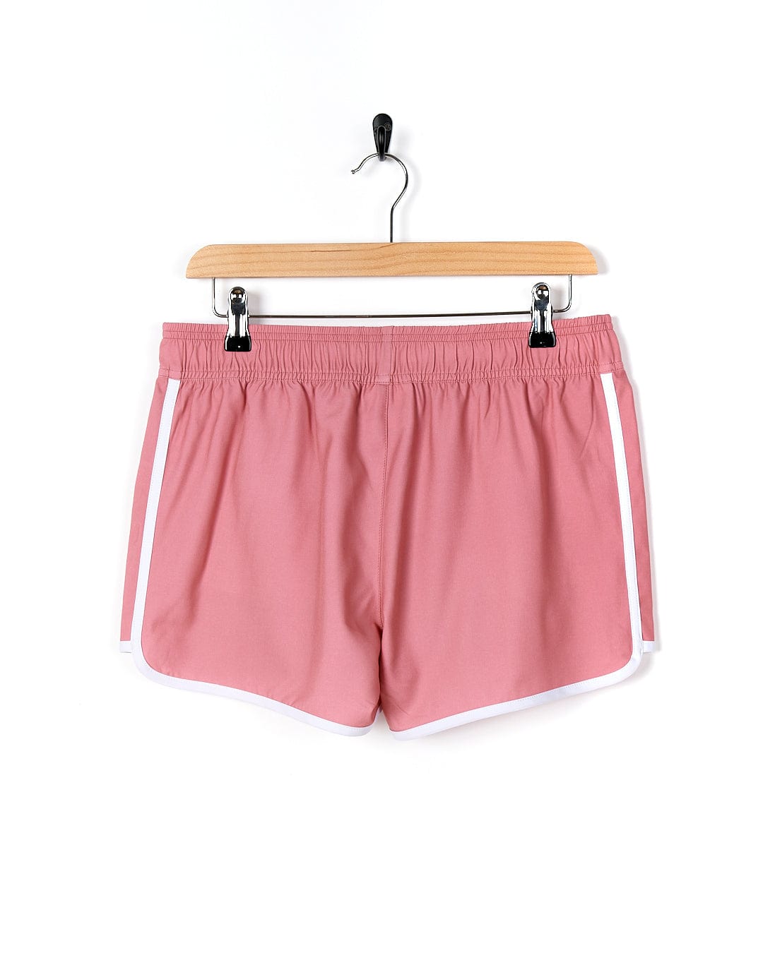 A Saltrock women's Fonte Volley - Womens Boardshort - Pink with an elasticated waist, ideal for the beach, hanging on a hanger.