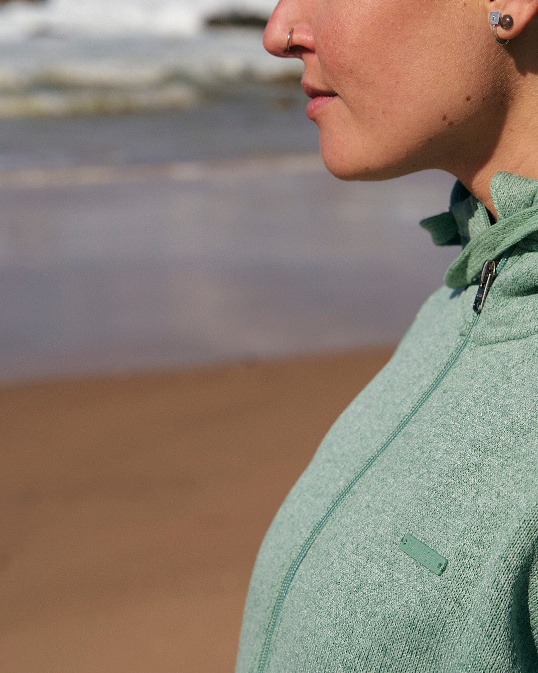 A woman wearing a Saltrock Galaksea - Womens 1/4 Zip Fleece - Light Green hoodie.