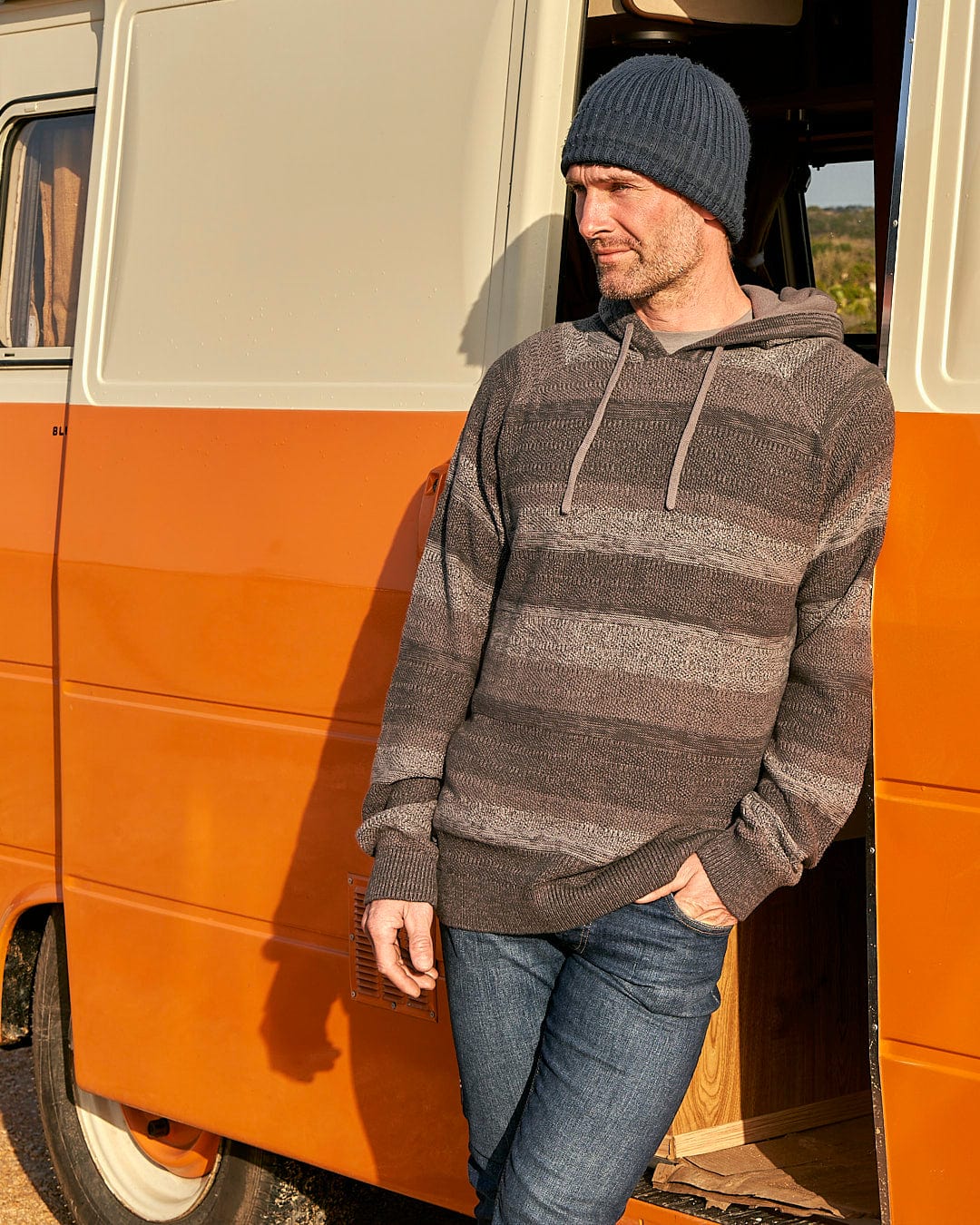A man standing next to an orange van with a Saltrock Grohl - Mens Knitted Hoodie - Dark Grey on his head.