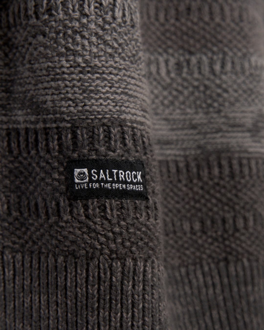 A close up of a Grohl - Mens Knitted Hoodie - Dark Grey with the Saltrock logo on it.