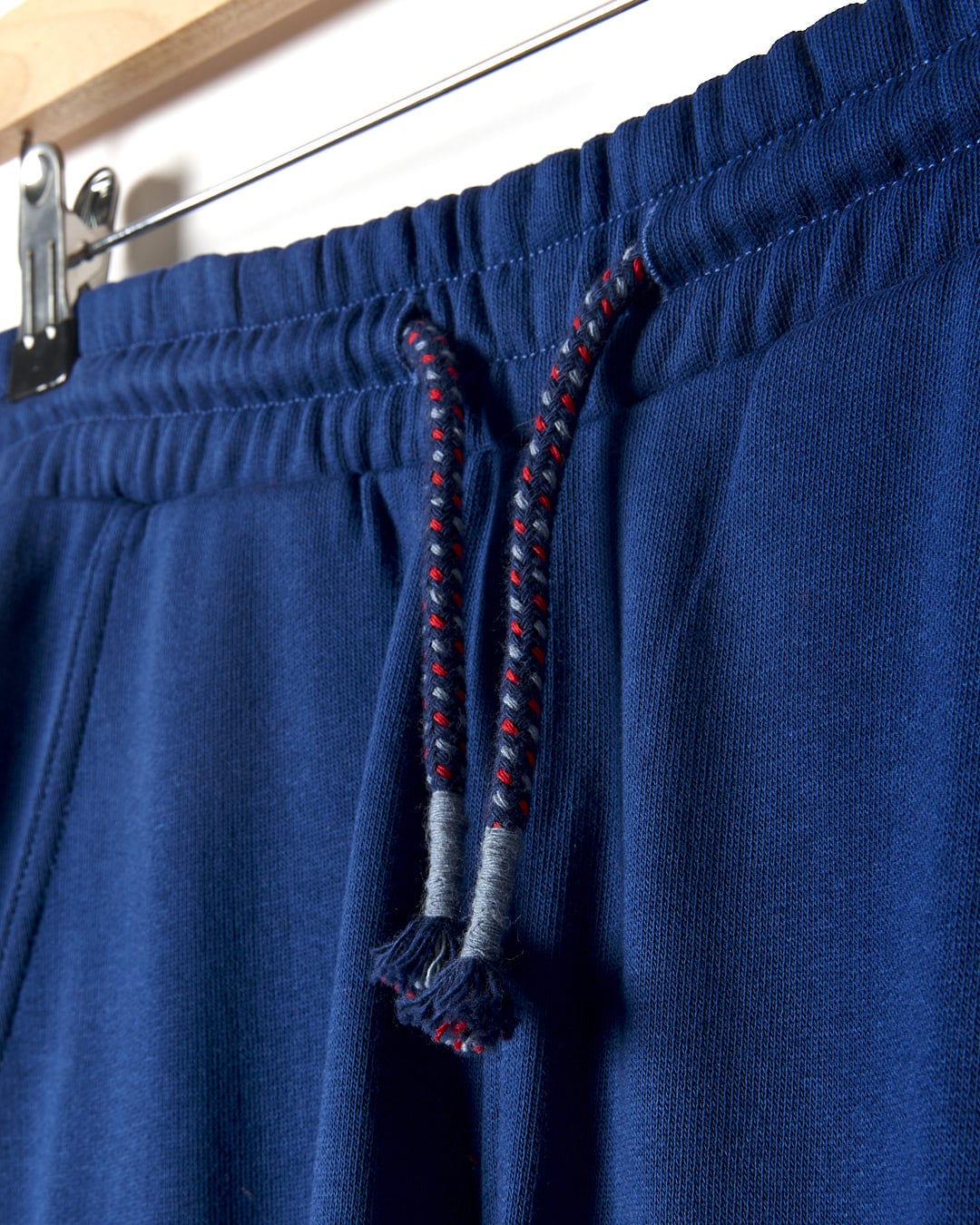 A pair of Saltrock - Jakub Kids Cargo Trouser - Blue hanging on a hanger.