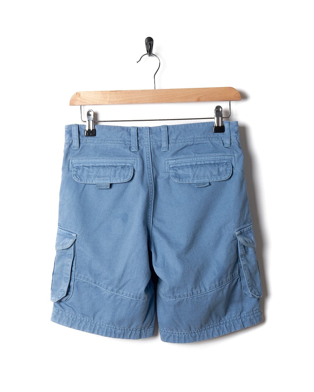 A pair of Saltrock Kaleb - Kids Cargo Shorts - Light Blue hanging on a hanger.