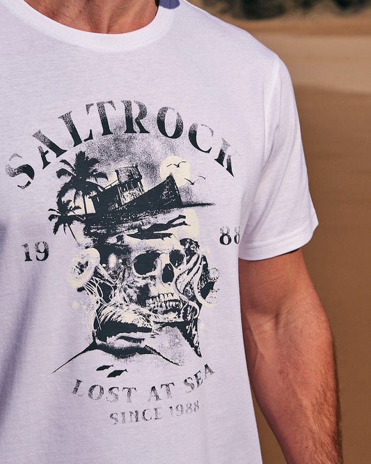 A man wearing a Saltrock t-shirt that says Lost At Sea Skull - Mens Short Sleeve T-Shirt - White lost at sea.