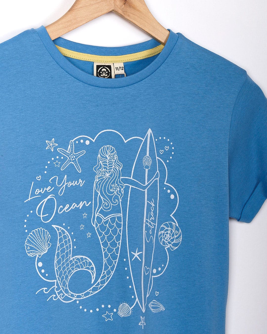 A Mermaid Surf - Kids Short Sleeve T-Shirt - Light Blue featuring a mermaid image embracing the surf lifestyle by Saltrock.