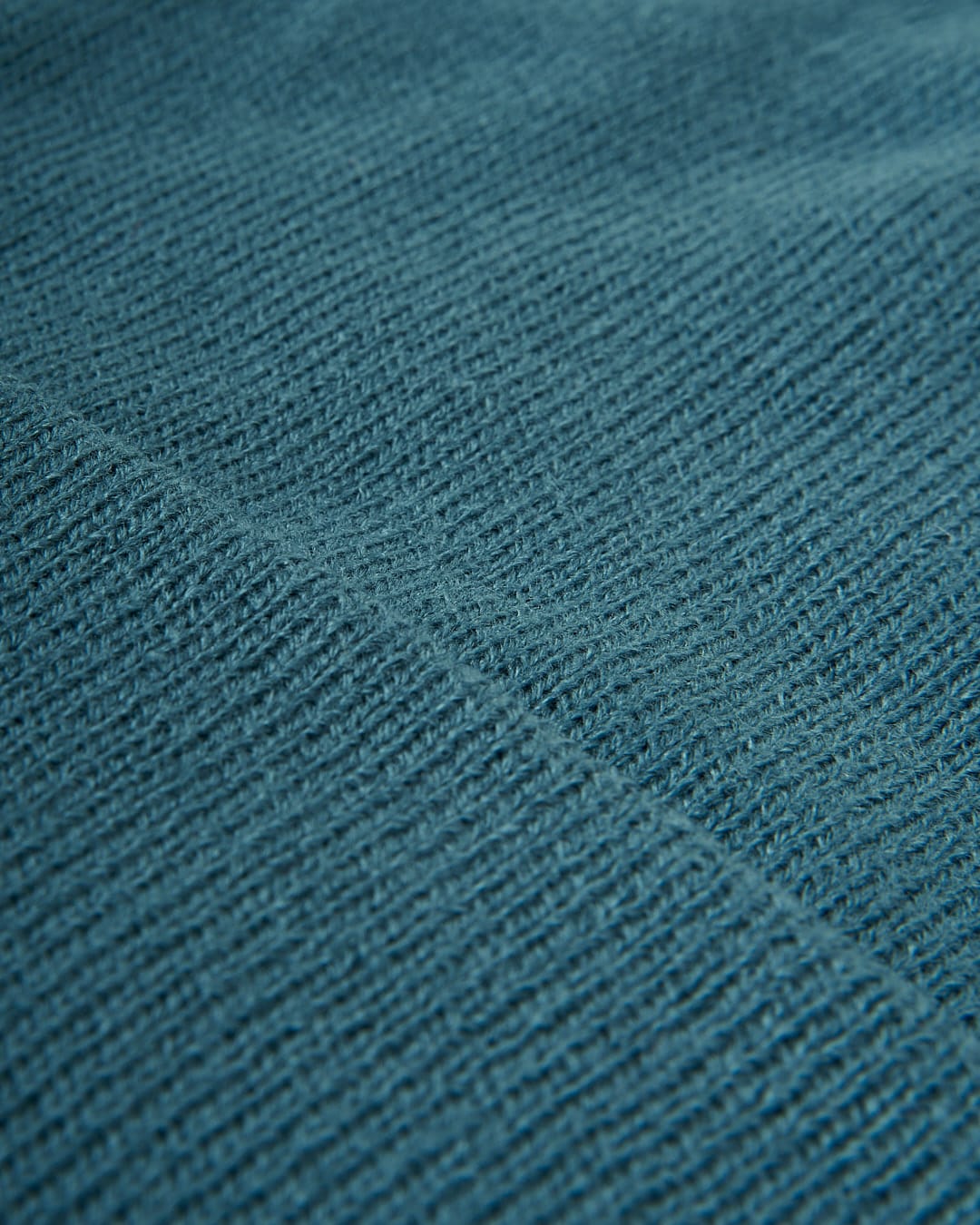 A close up image of a Saltrock Ok - Tight Knit Beanie in Teal, winter warmer fabric.