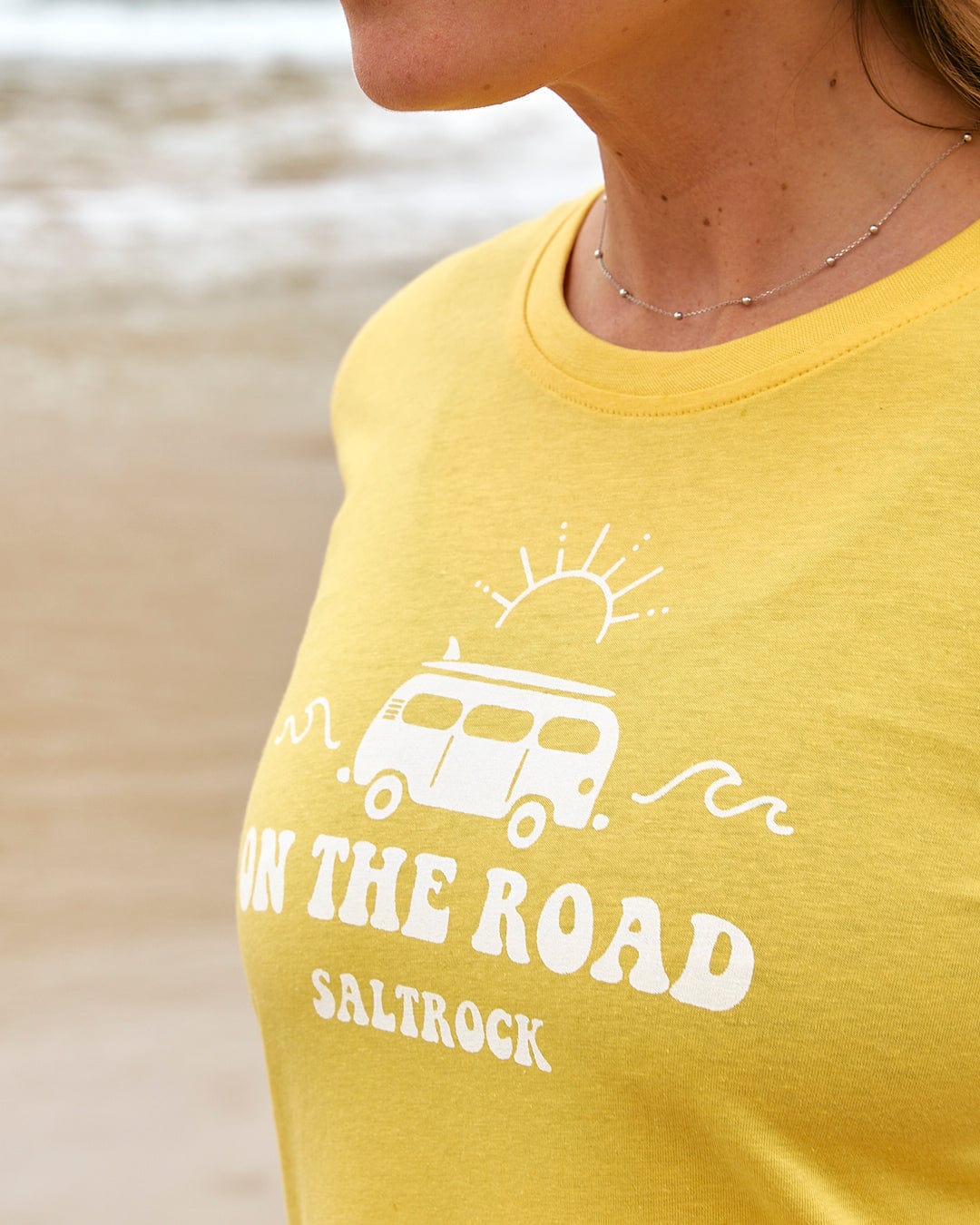 A woman wearing a yellow t-shirt that says 
