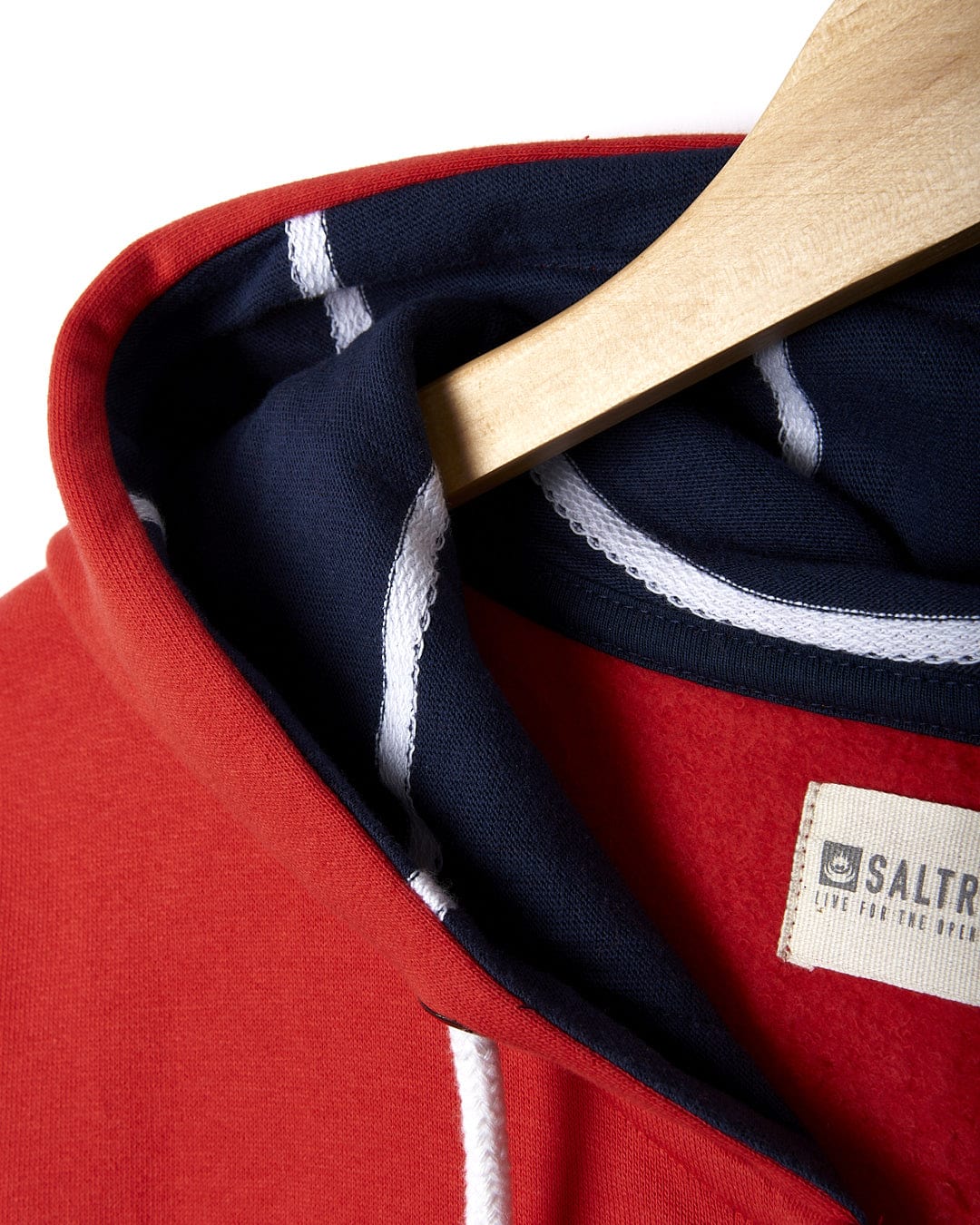 A Saltrock On The Road Wales - Women's Zip Hoodie - Red and navy hoodie hanging on a wooden hanger.