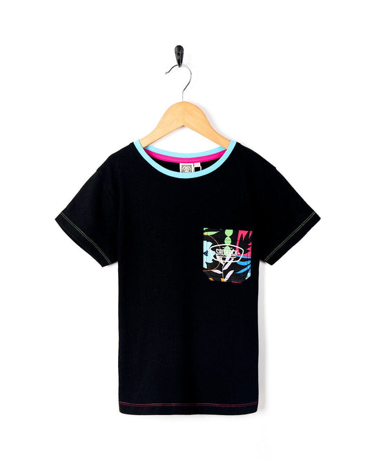 A Rayssa - Kids Short Sleeve Pocket T-Shirt - Black with colorful trim on a Saltrock swinger.