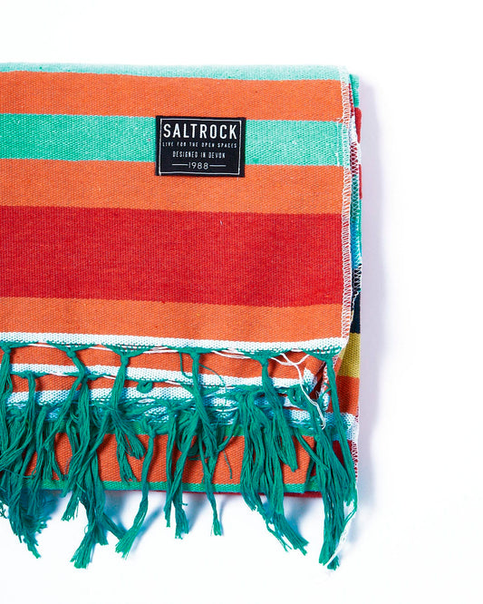 A colorful striped Recycled Picnic Blanket - Multi with fringes on it by Saltrock.