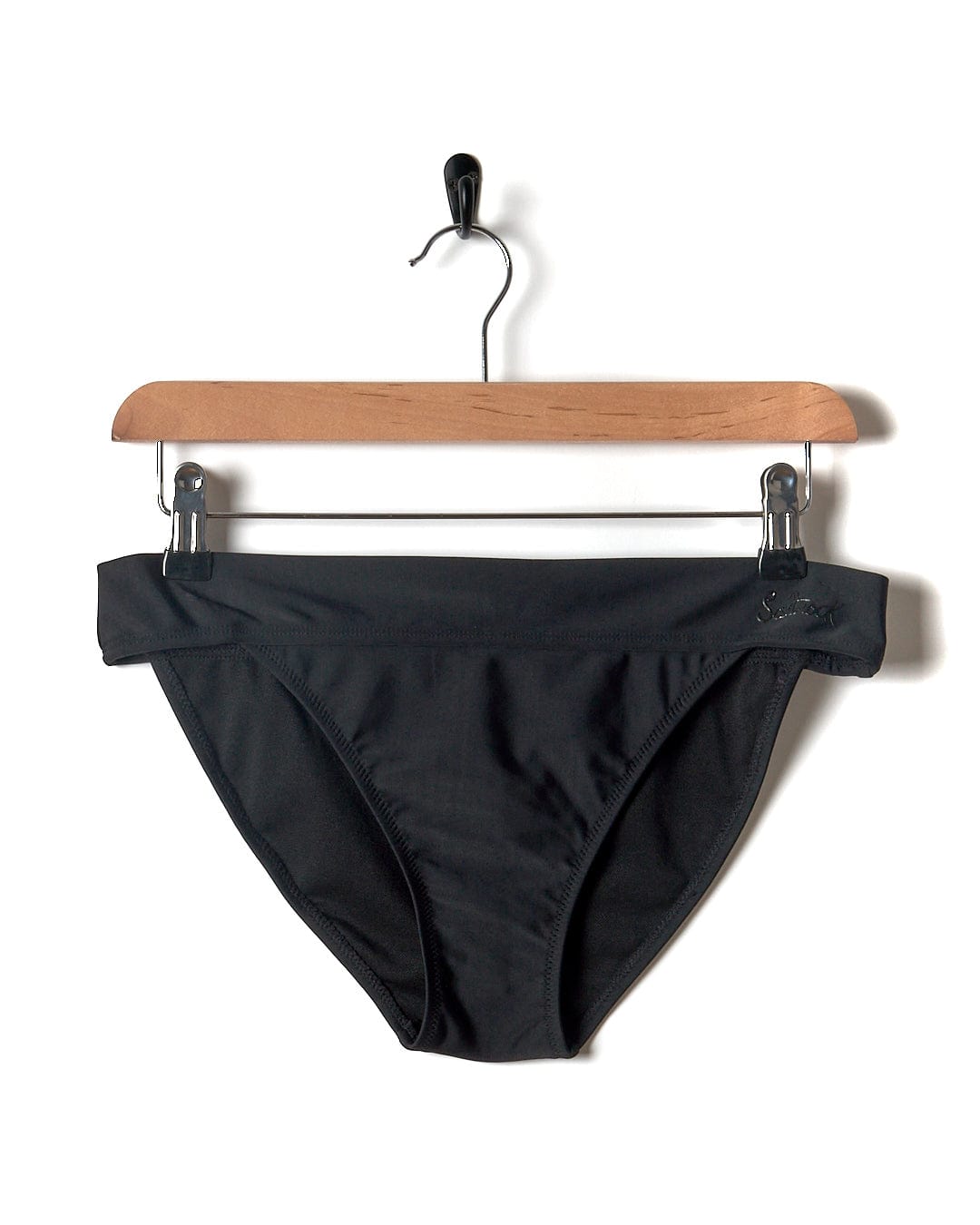 A Rosie - Womens Bikini Bottom - Black hanging on a hanger, perfect for a beach or pool day by Saltrock.