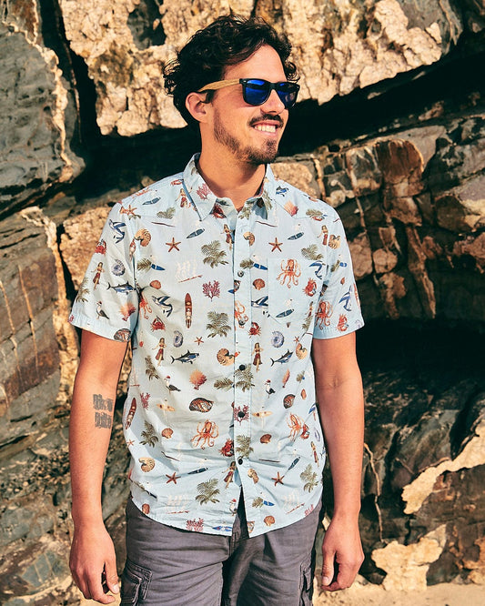 A man wearing sunglasses and a Saltrock Ruan - Mens Washed Short Sleeve Shirt with animals on it, giving off holiday vibes.