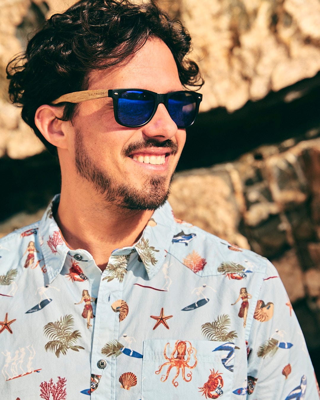 A man wearing a Saltrock Ruan - Mens Washed Short Sleeve Shirt in Light Blue and sunglasses.