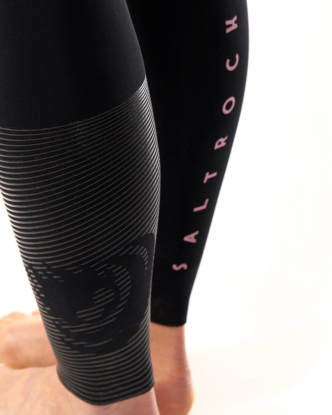 A woman's leg with the Saltrock Shockwave - Womens 3/2 Front Zip Full Wetsuit - Black on it.