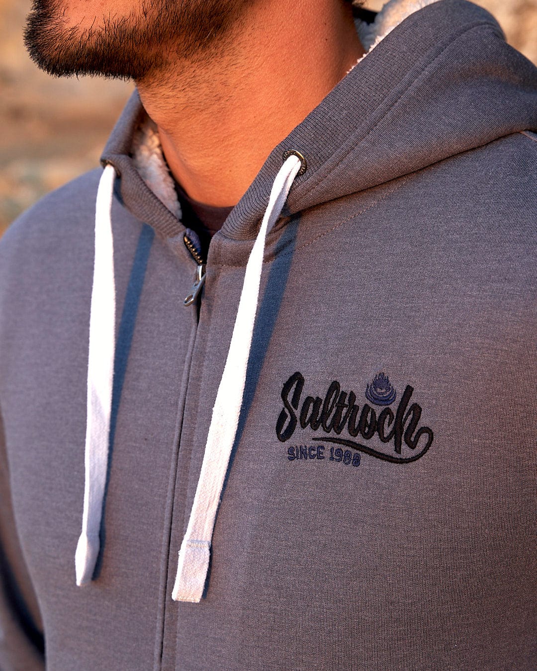 A man wearing a Speed - Mens Borg Lined Hoodie - Grey with the brand name Saltrock on it.
