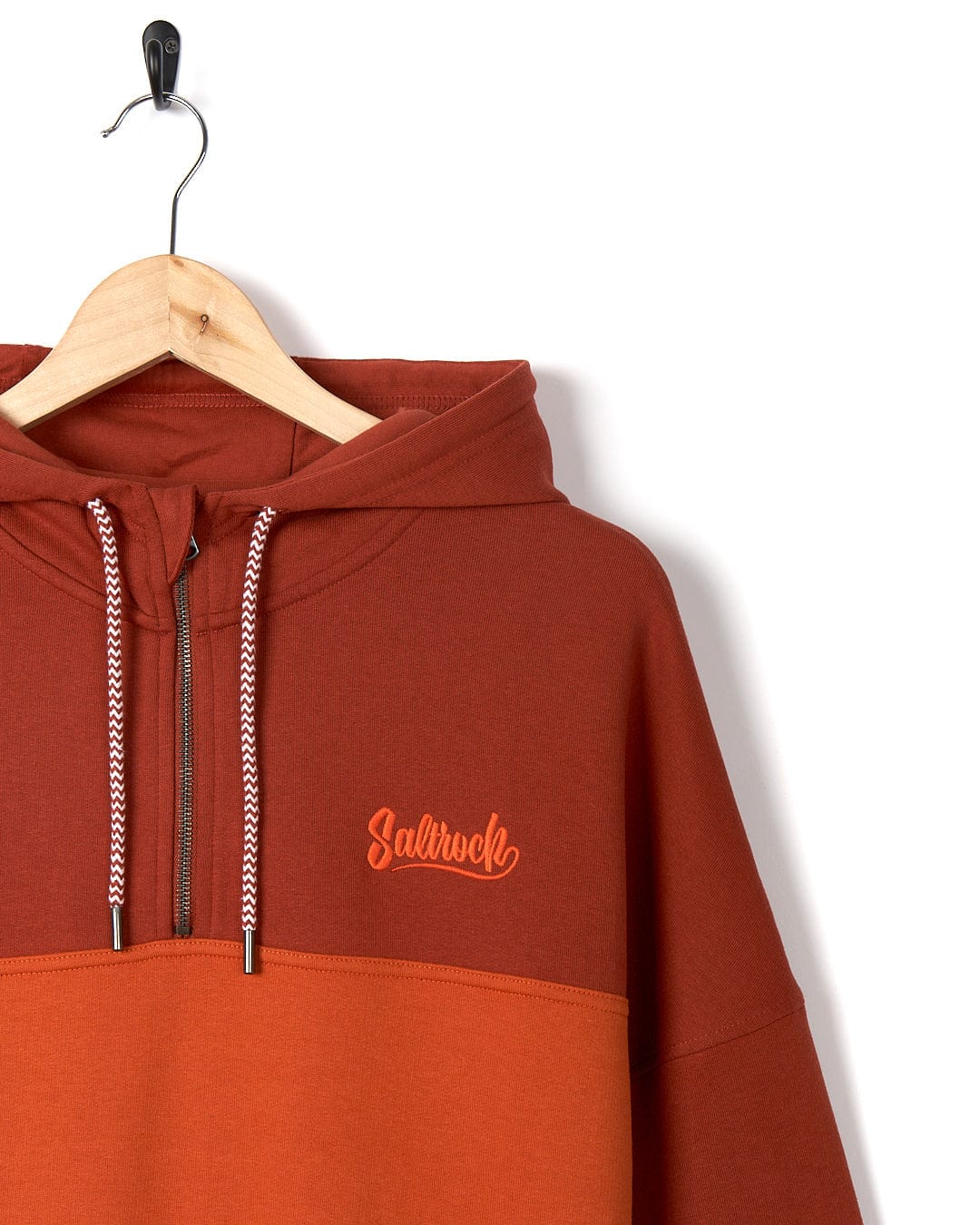 A Saltrock Speed Embroidery - Mens 1/4 Neck Zip - Red hooded sweatshirt hanging on a hanger.