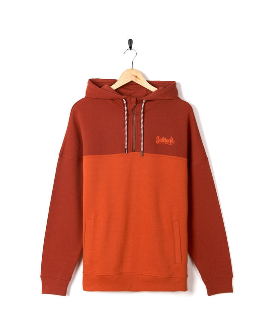 A Saltrock Speed Embroidery - Men's 1/4 Neck Zip - Red hoodie hanging on a hanger.