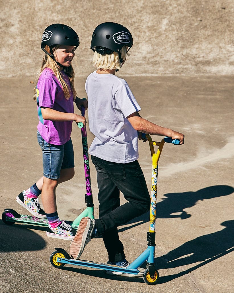 Two kids riding Saltrock Warped - Stunt Scooters - Blue in a parking lot.
