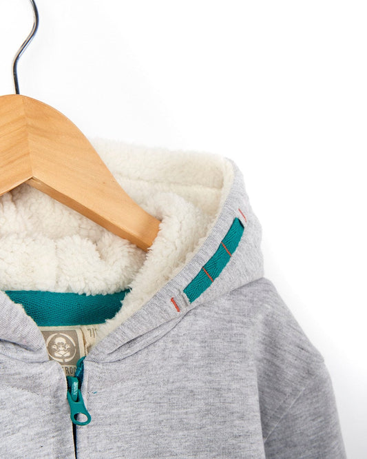 A Watergate - Kids Lined Hoodie - Grey with a green trim hanging on a wooden hanger. (Brand Name: Saltrock)