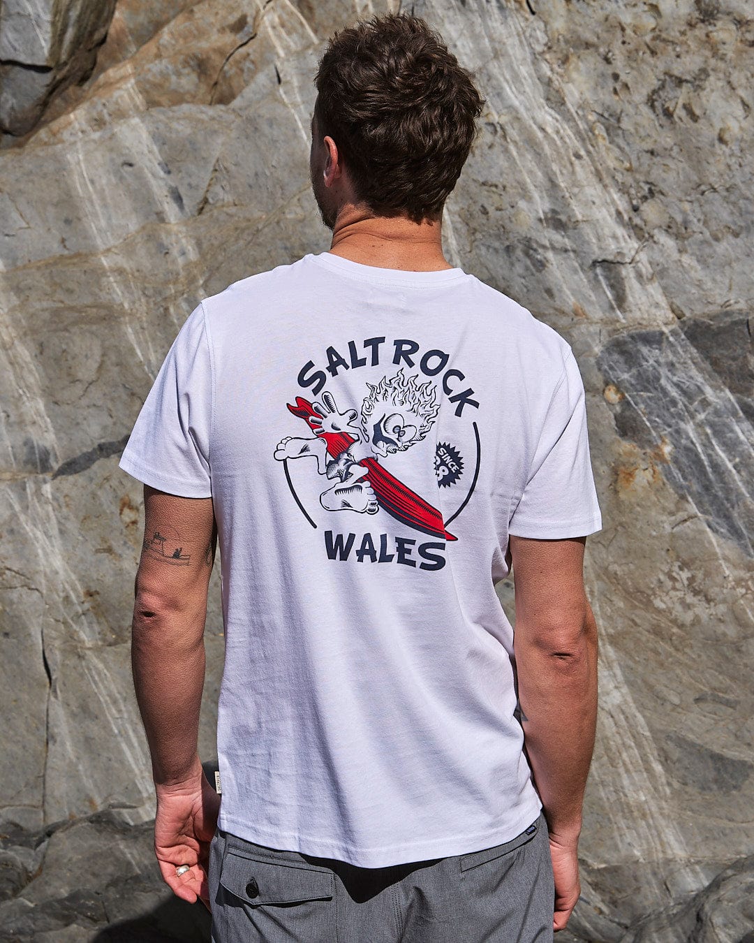 A man wearing a Wave Rider Wales - Mens Short Sleeve T-Shirt - White by Saltrock.