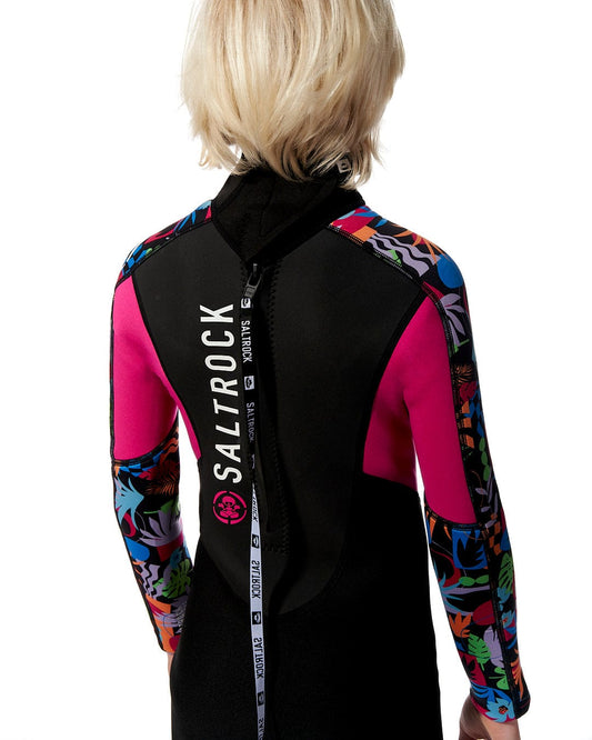 A young girl wearing a Zephyr - Kids 3/2 Full Wetsuit in Black by Saltrock.
